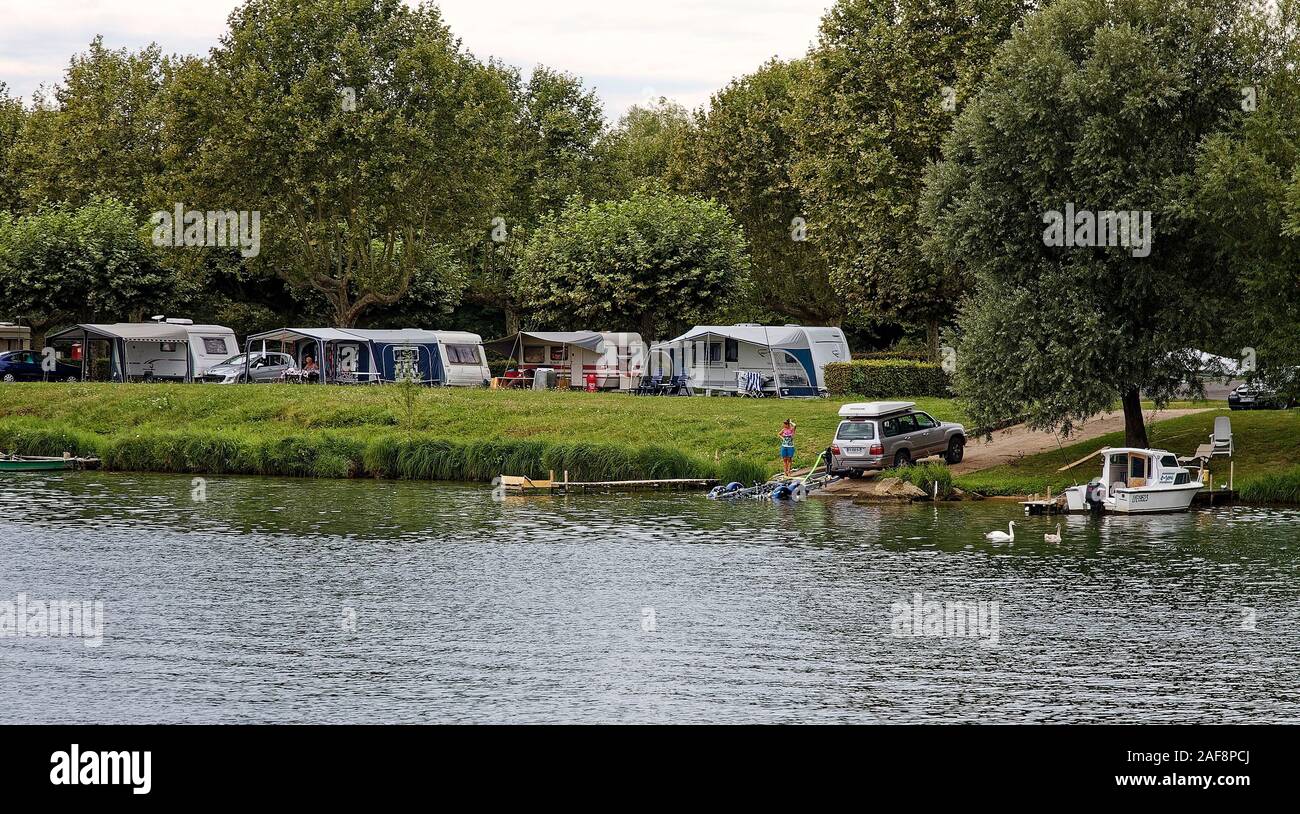 campers, riverside, boat, RVs, recreational vehicles, awnings, grass, trees, vacation, leisure, Soane River, France, summer; horizontal Stock Photo