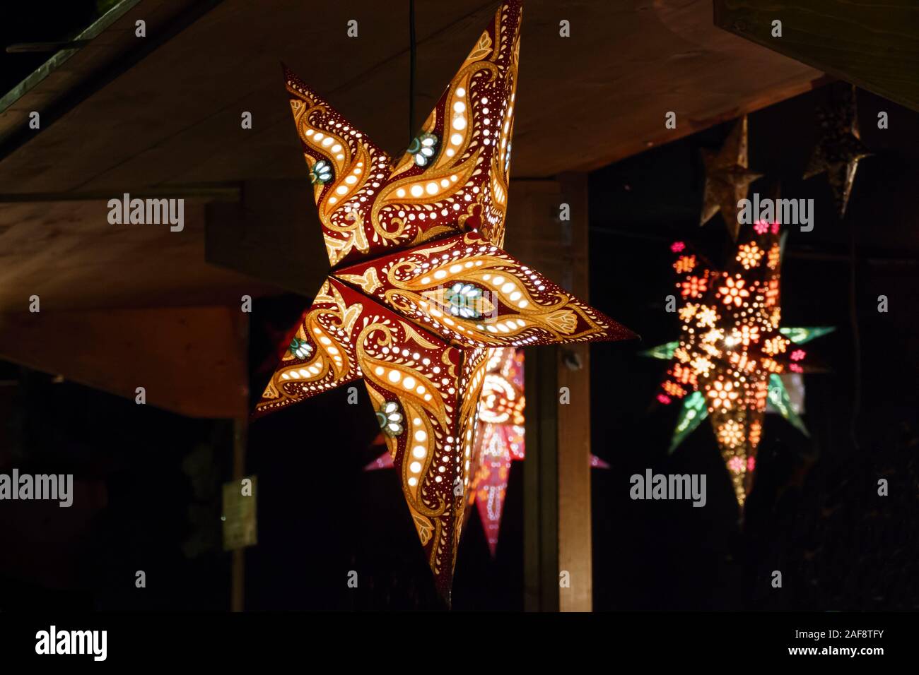 beleuchtete Sterne in bunten Farben auf dem Weihnachtsmarkt Stock Photo