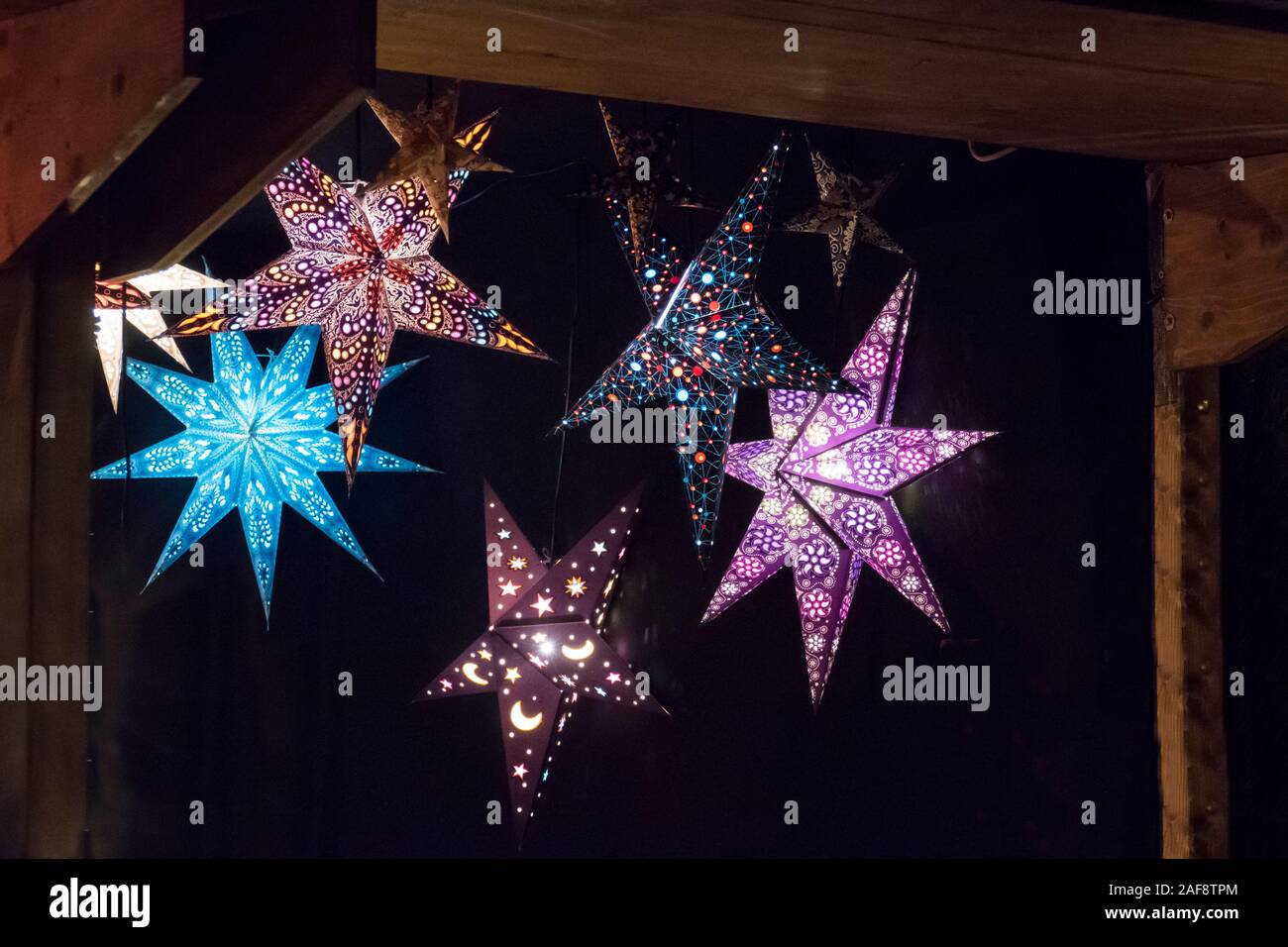 beleuchtete Sterne in bunten Farben auf dem Weihnachtsmarkt Stock Photo