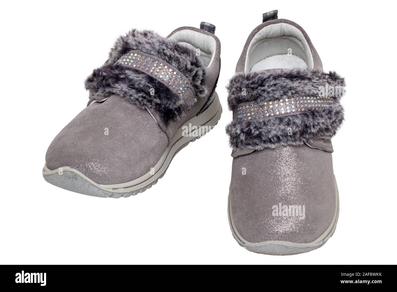 Child shoes fashion. Close-up of a pair beautiful gray silver suede sneaker or sports shoes for girls with fur and rhinestone decoration isolated on a Stock Photo