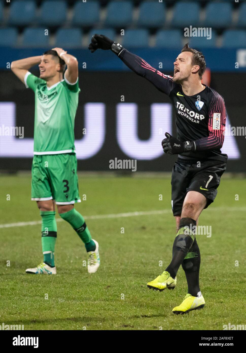 13 December 2019, North Rhine-Westphalia, Bochum: Soccer: 2nd Bundesliga, VfL Bochum - Hannover 96, 17th matchday in the Vonovia Ruhrstadion. Bochum goalkeeper Manuel Riemann (r) cheers after a parade. Miiko Albornoz from Hanover grabs his head. Photo: Bernd Thissen/dpa - IMPORTANT NOTE: In accordance with the requirements of the DFL Deutsche Fußball Liga or the DFB Deutscher Fußball-Bund, it is prohibited to use or have used photographs taken in the stadium and/or the match in the form of sequence images and/or video-like photo sequences. Stock Photo