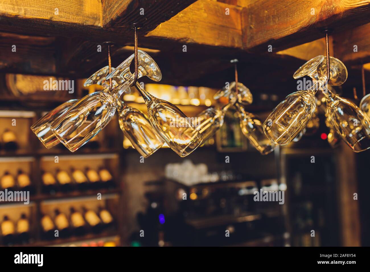 Group Of Empty Wine Glasses Hanging From Metal Beams In A Bar Stock group-of-empty-wine-glasses-hanging-from-metal-beams-in-a-bar-stock