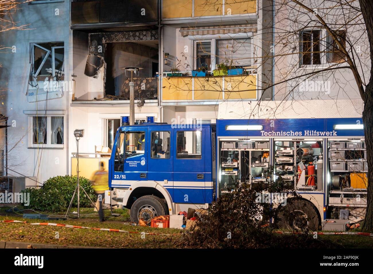 Blankenburg, Germany. 13th Dec, 2019. After a serious explosion in a multi-family house in Blankenburg in the Harz Mountains, some balconies of the house are black with soot. In front of the house there is a vehicle of the Technical Relief Agency (THW). Specialists of the relief organization want to support the ceilings of the building still at night, so that it does not collapse. A 78-year-old man died in the explosion, at least eleven people were injured, some of them seriously. Credit: Mattis Kaminer/Alamy Live News Stock Photo