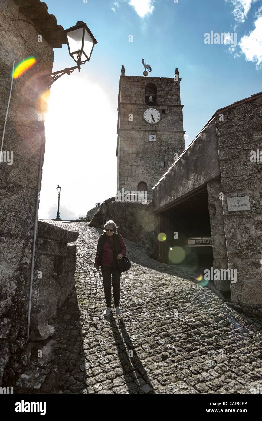 Serra da Estrela, Portugal. A senior woman tourist walking in a cobbled street in the Portuguese village of Linhares. Stock Photo