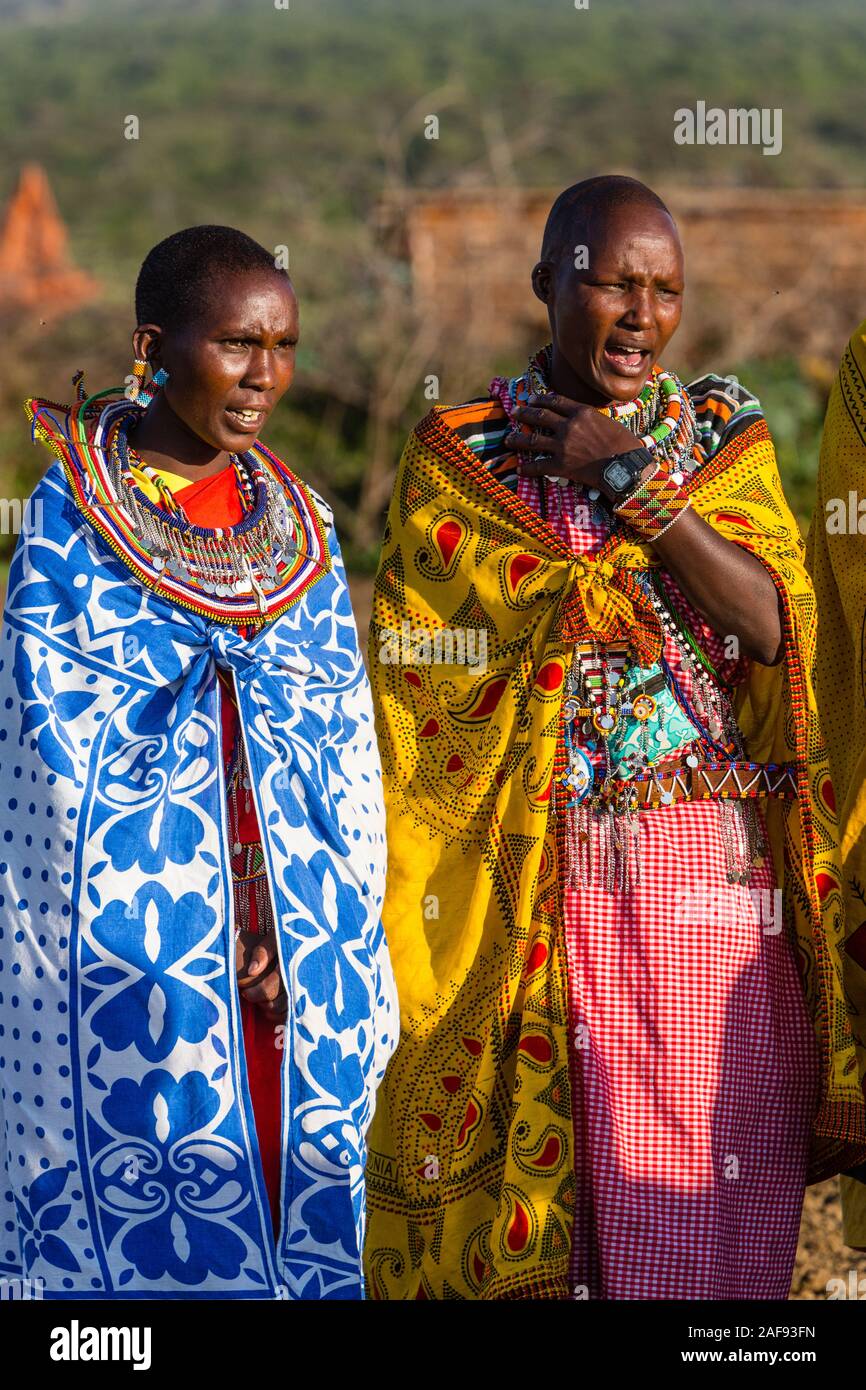 Tanzania. Maasai Village of Ololosokwan, Northern Serengeti.  Women Villagers Wearing Traditional Dress. Stock Photo