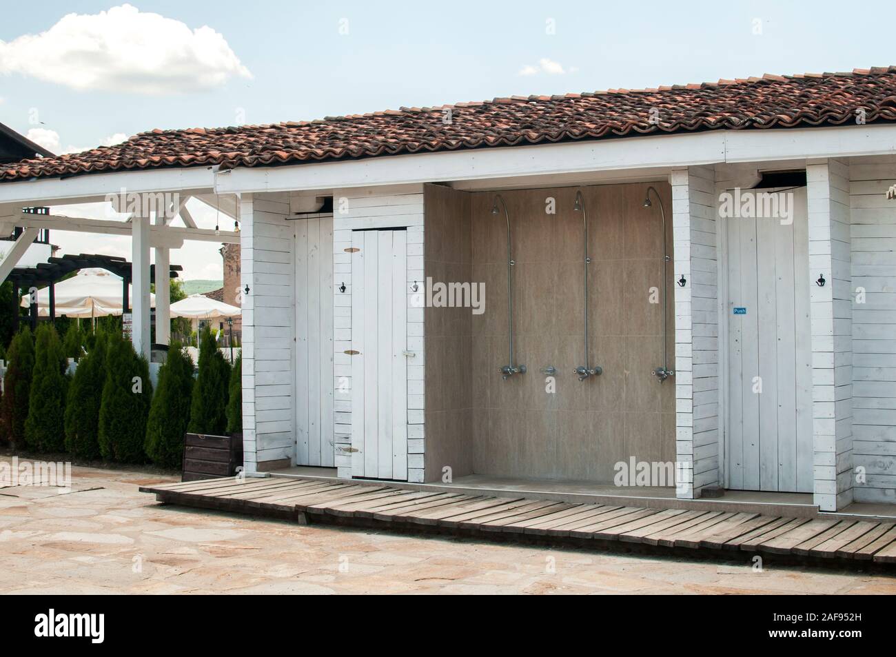 Wooden cabin with changing rooms and showers at hotel's outdoor swimming pool Stock Photo