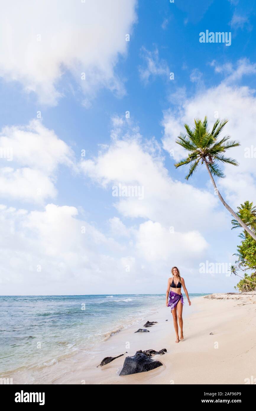 A woman walking along an idyllic tropical beach Stock Photo