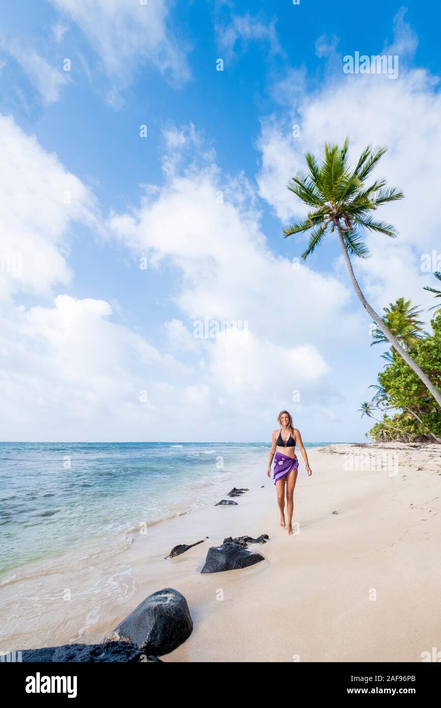 A woman walking along an idyllic tropical beach Stock Photo