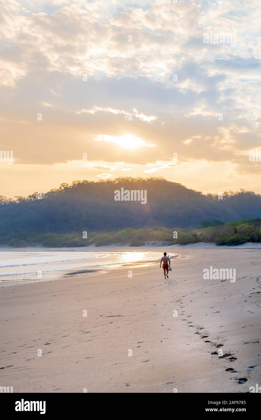 A solo surfer on Ocotal beach, San Juan del Sur, Nicaragua Stock Photo