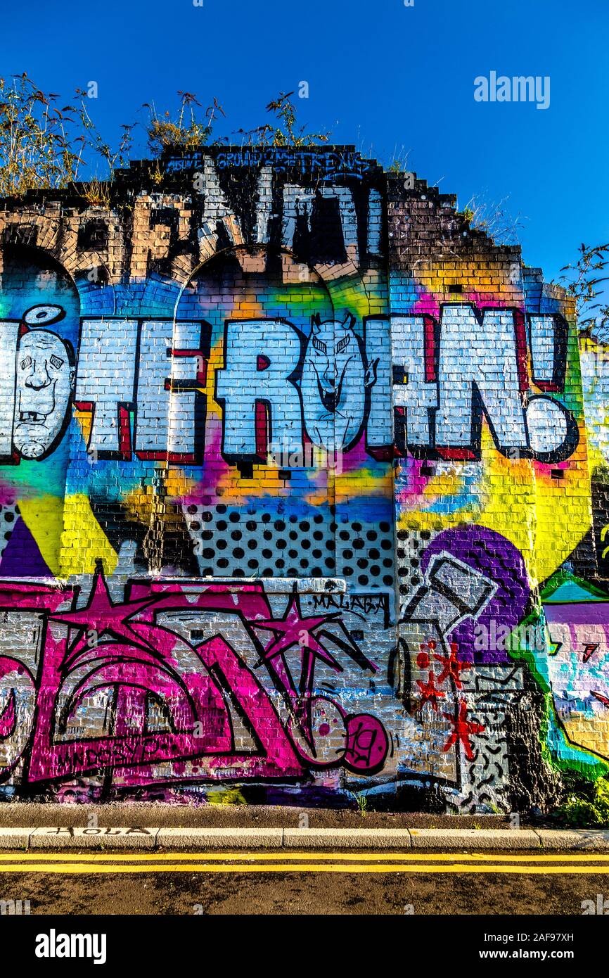 Wall by Pedley Street Arch covered with murals, graffiti and street art, London, UK Stock Photo