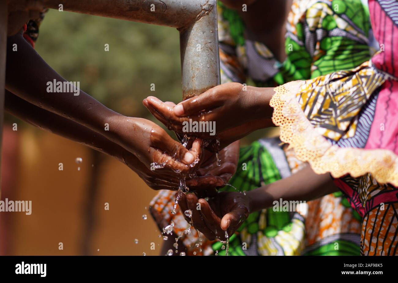 Hands under Tap from African Black Children with Fresh Clean Water Stock Photo