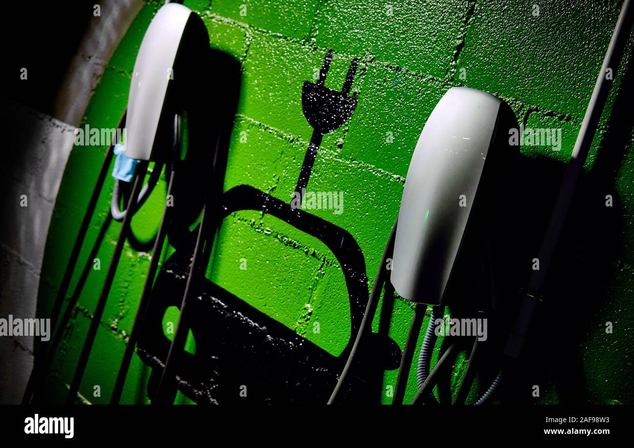 Electric vehicle charging station, free parking place green colored painted on wall symbol close up, no people Stock Photo