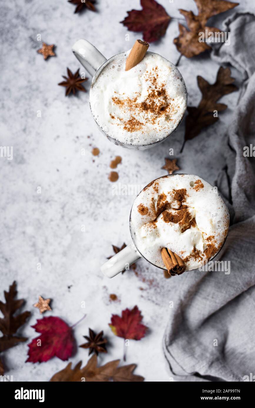 Pumpkin Spiced Latte With Whipped Cream Topping And Cinnamon Dusting Surrounded By Leaves And Spices Stock Photo