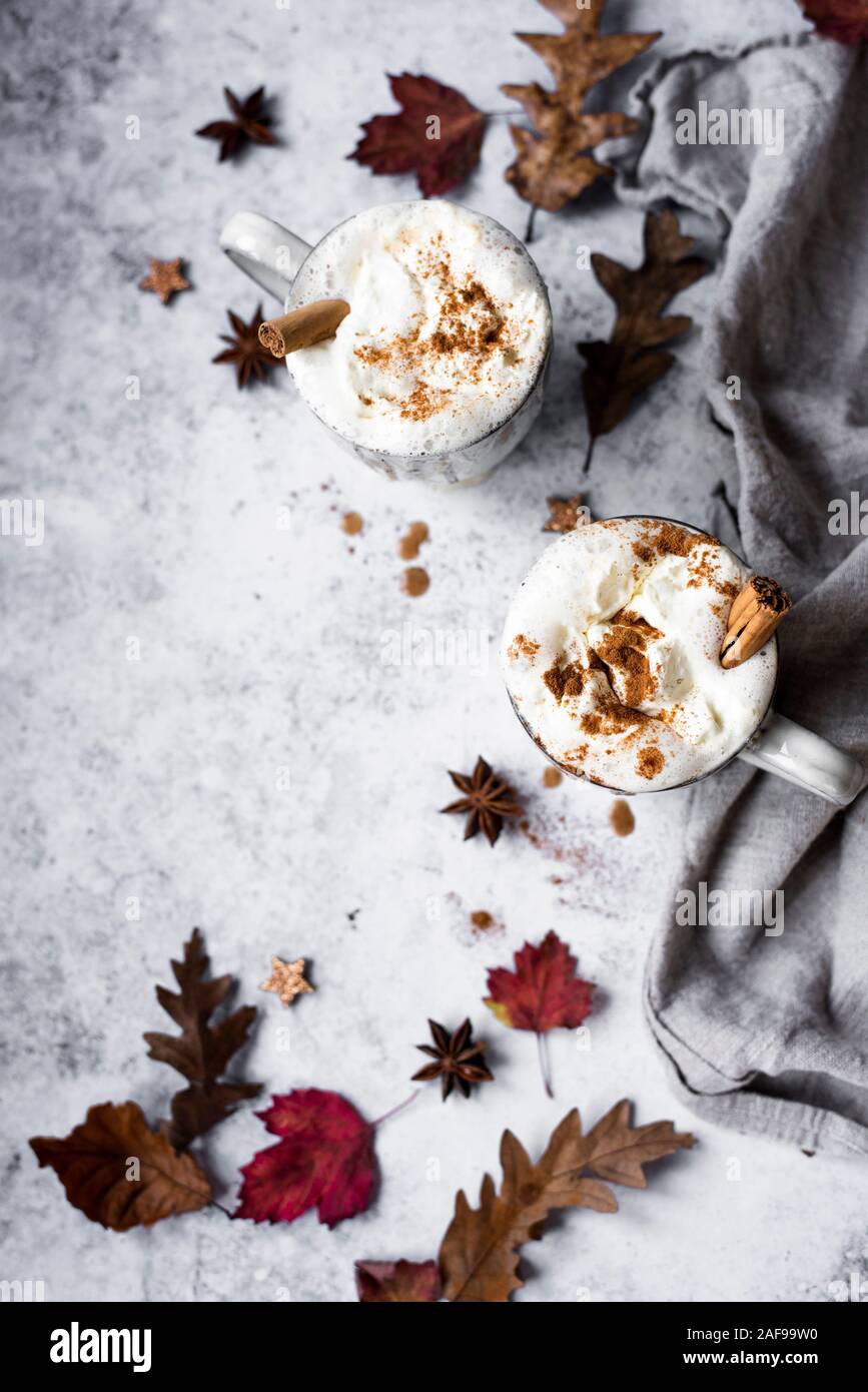 Pumpkin Spiced Latte With Whipped Cream Topping And Cinnamon Dusting Surrounded By Leaves And Spices Stock Photo