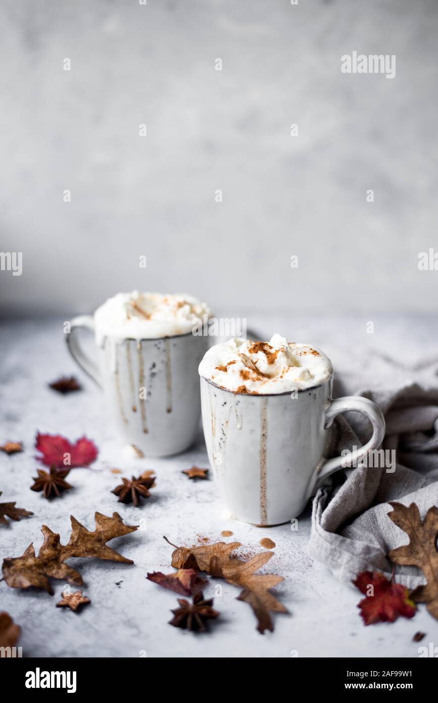 Pumpkin Spiced Latte With Whipped Cream Topping And Cinnamon Dusting Surrounded By Leaves And Spices Stock Photo