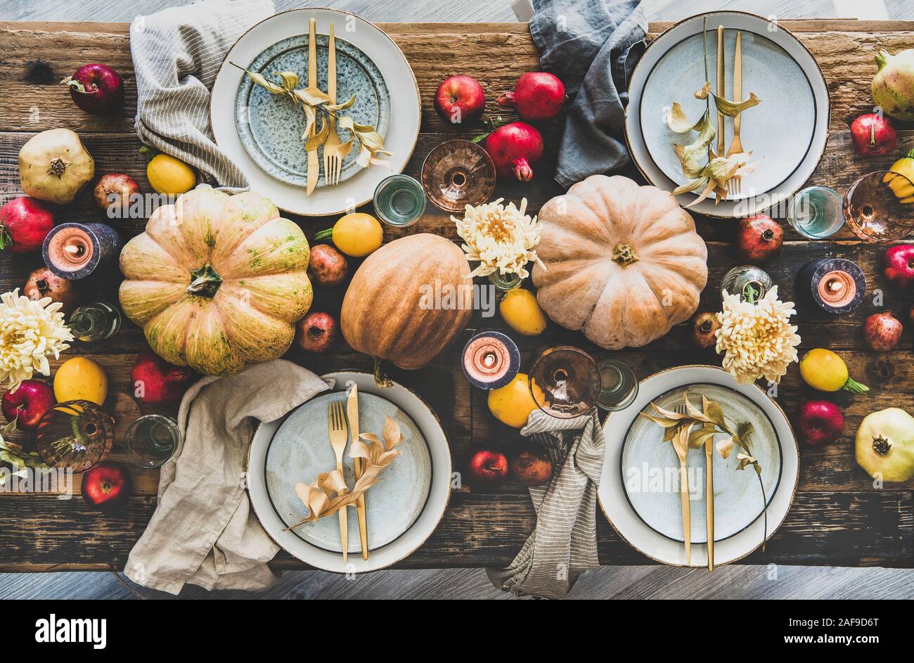 Fall celebration table setting for Thanksgiving day party or family  gathering dinner. Flat-lay plates, silverware, floral and fruit decoration,  candle Stock Photo - Alamy