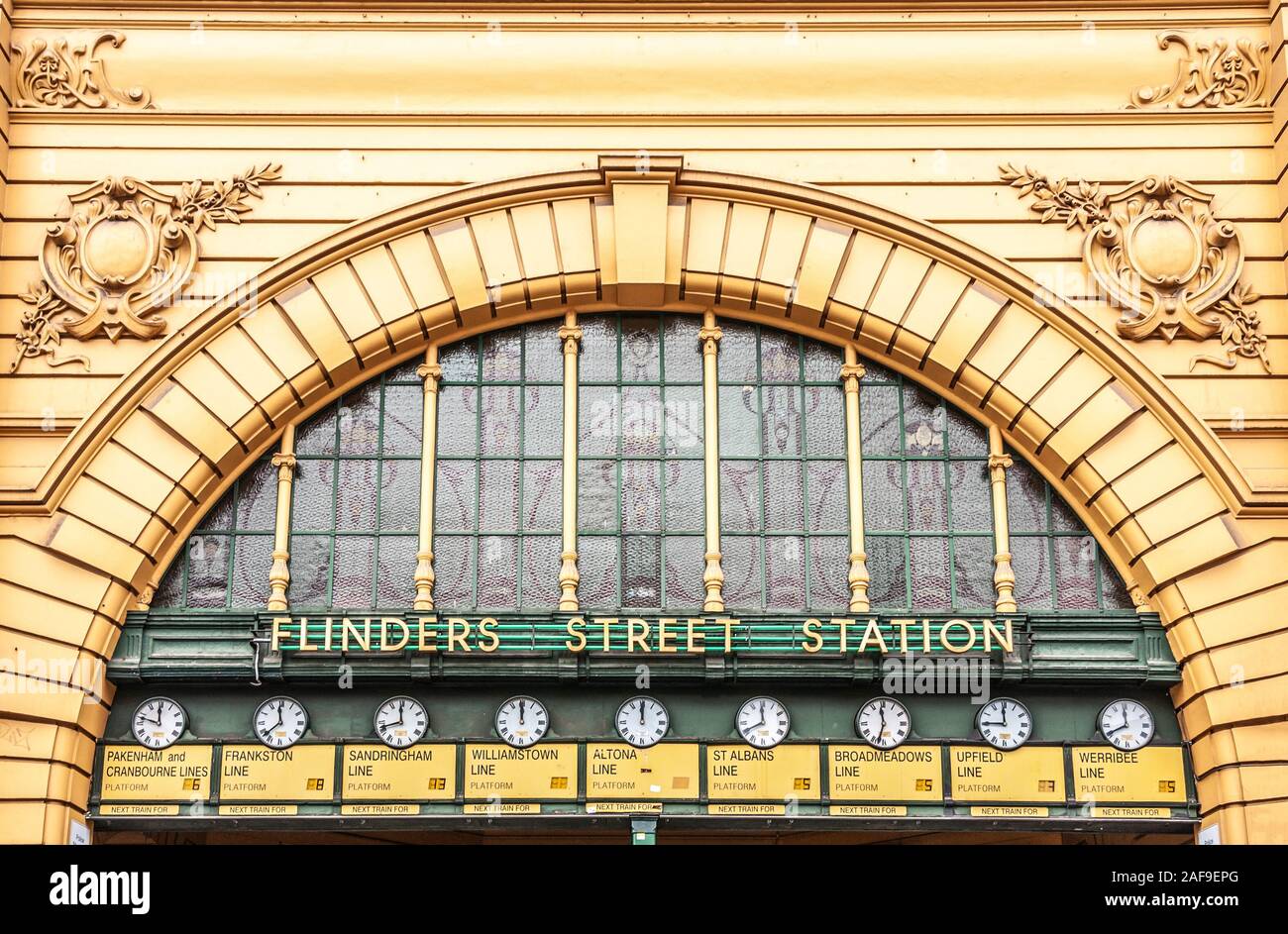 Melbourne, Australia - November 17, 2009: Detail of yellow facade of Flinders Street Station with window under large bow, name of building, freso and Stock Photo