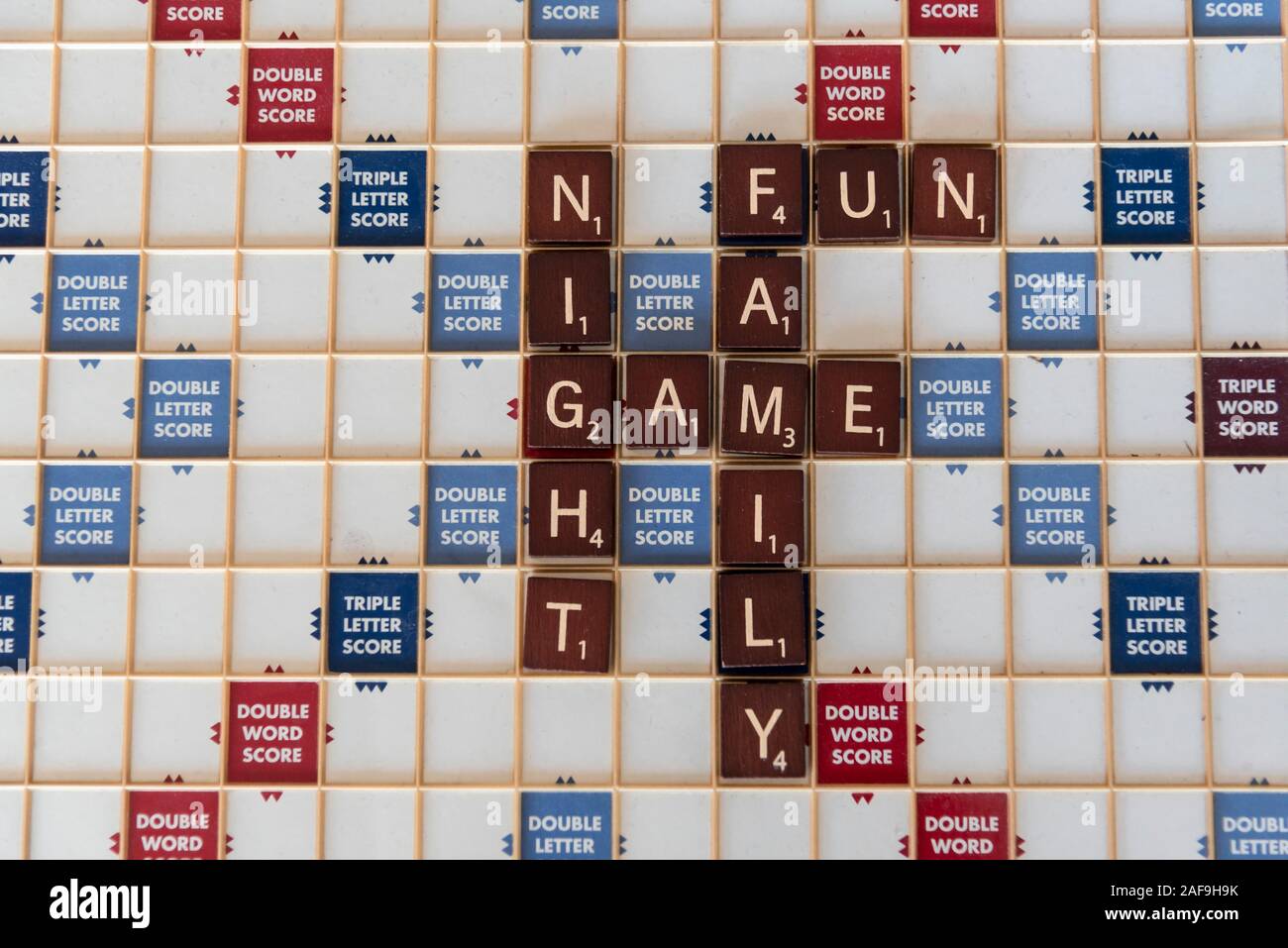 Overhead board game letter tiles spelling out family fun game night. Stock Photo