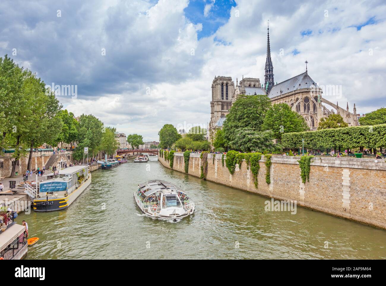 The cruise boat Trocadero on the River Seine motors past Notre Dame Cathedral in Paris. Stock Photo
