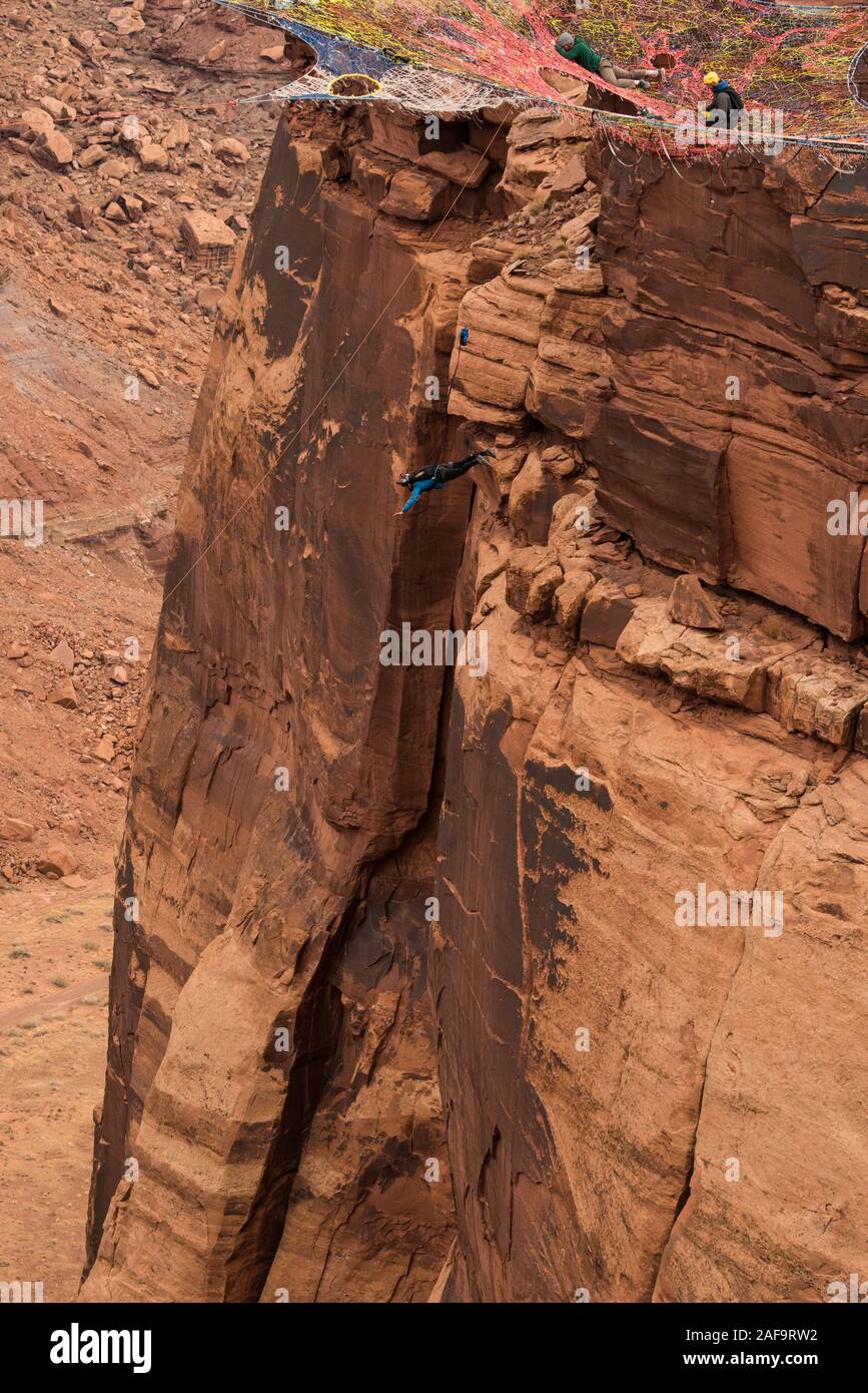 A female BASE jumper leaps from the Mothership Space Net suspended from the cliffs 950 vertical