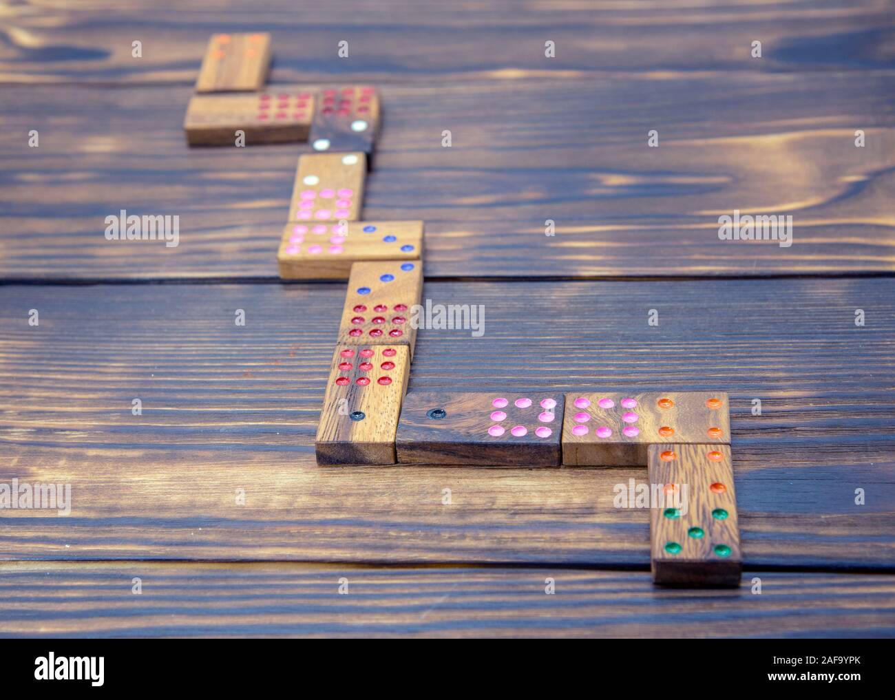 Playing dominoes on a wooden textured table. Stock Photo