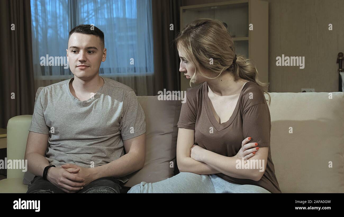 Frustrating couple. Offended girlfriend looks at her boyfriend Stock Photo