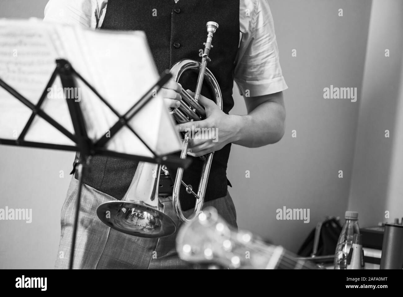 Flugelhorn in trumpeter hands. Retro stylized black and white photo