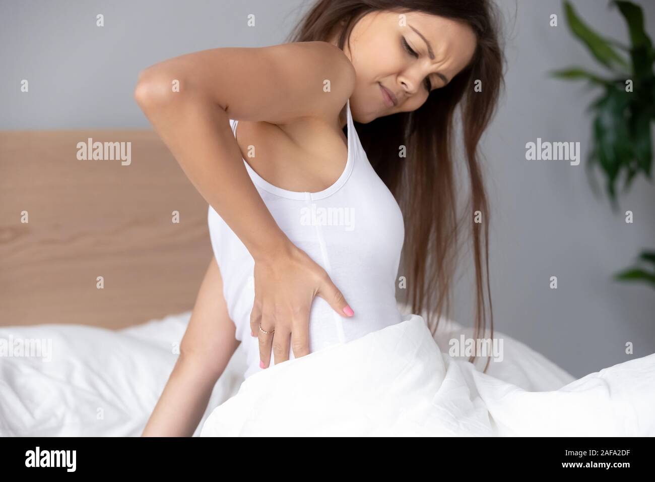 Hurt young woman massage back after bad sleep Stock Photo Alamy