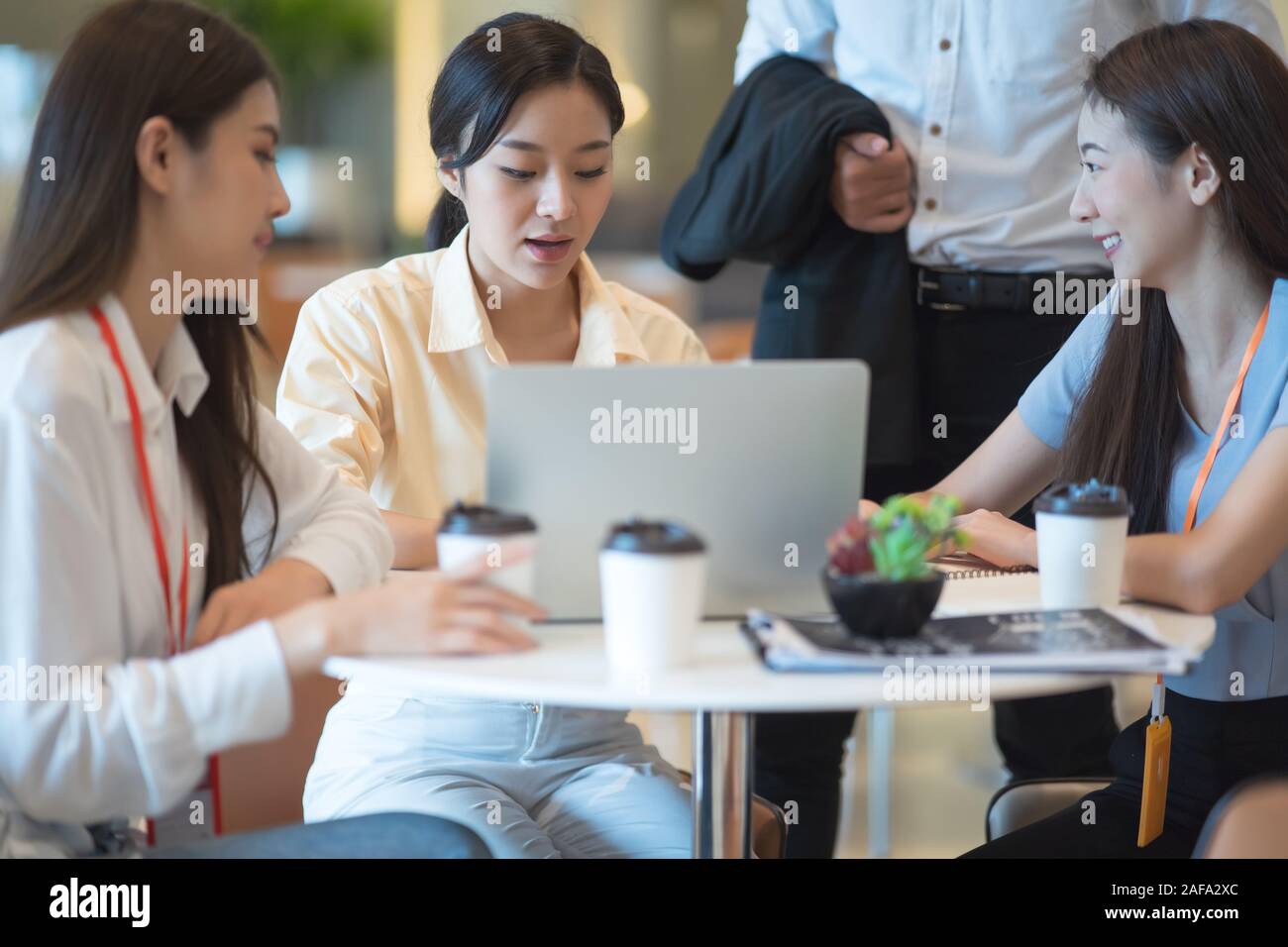 Young Asian woman and business people are meeting in office discussion with colleagues . Group of Business team working and share ideas about project Stock Photo