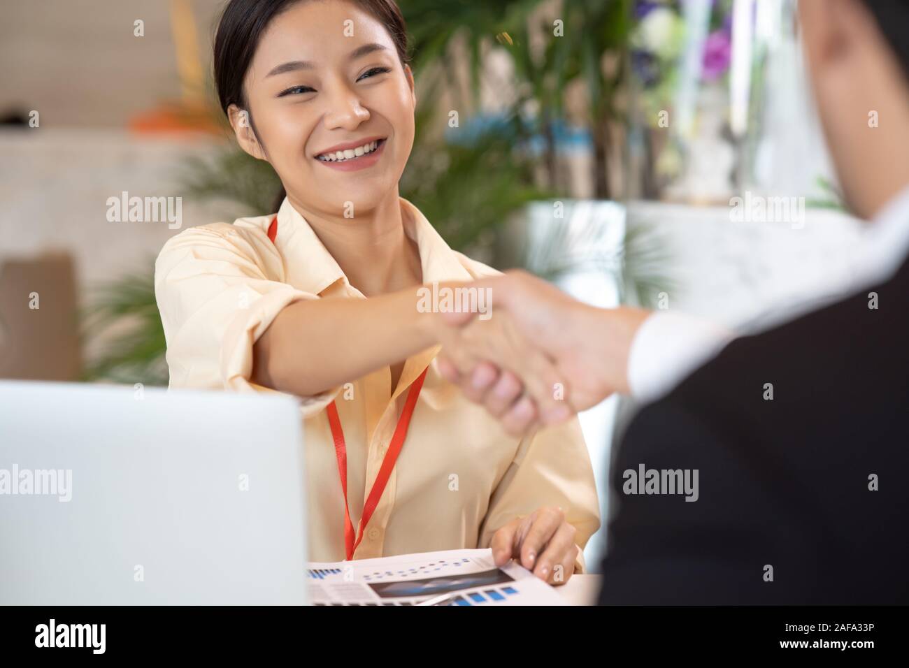 Portrait young Asian woman interviewer and interviewee shaking hands for a job interview .Business people handshake in modern office. Greeting deal co Stock Photo