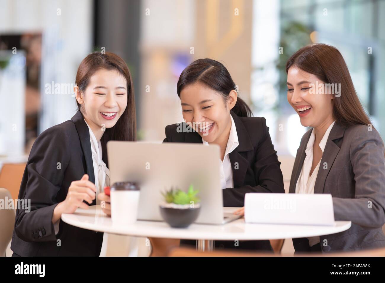 Group of Business woman meeting in a cafe and using laptop. Stock Photo