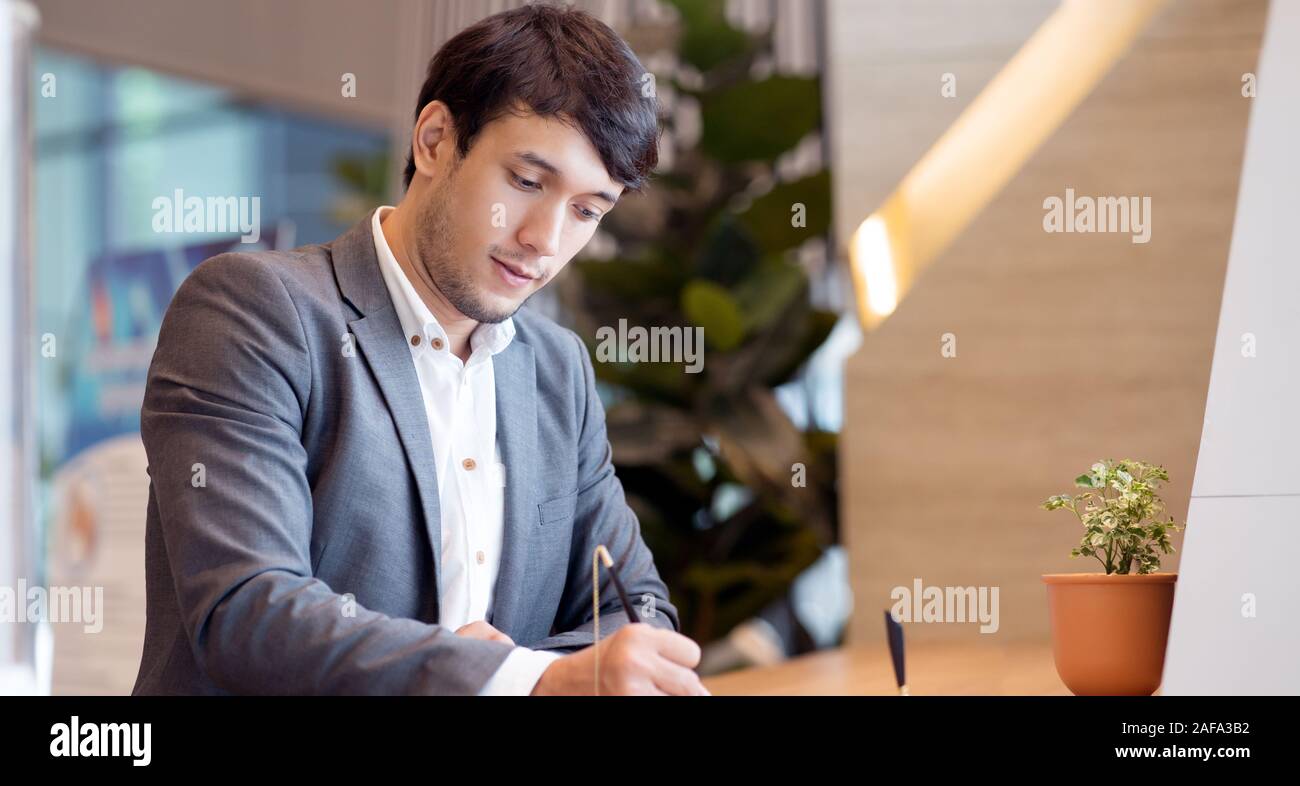 Asian businessman sign or write document in modern office Stock Photo