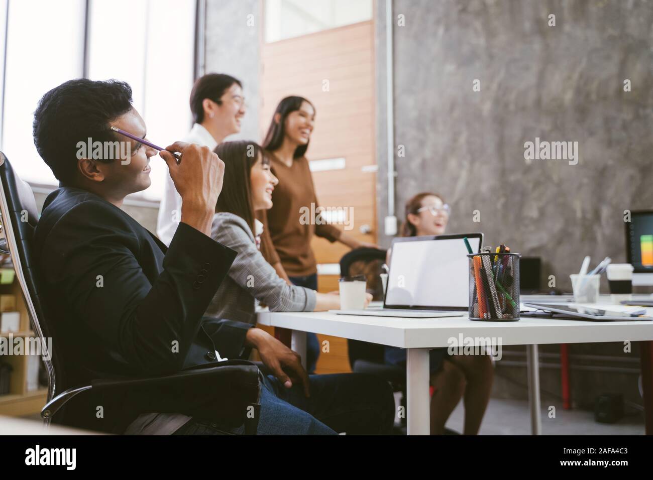 Group of happy Asian team creative business people laughing in meeting. teamwork concept Stock Photo