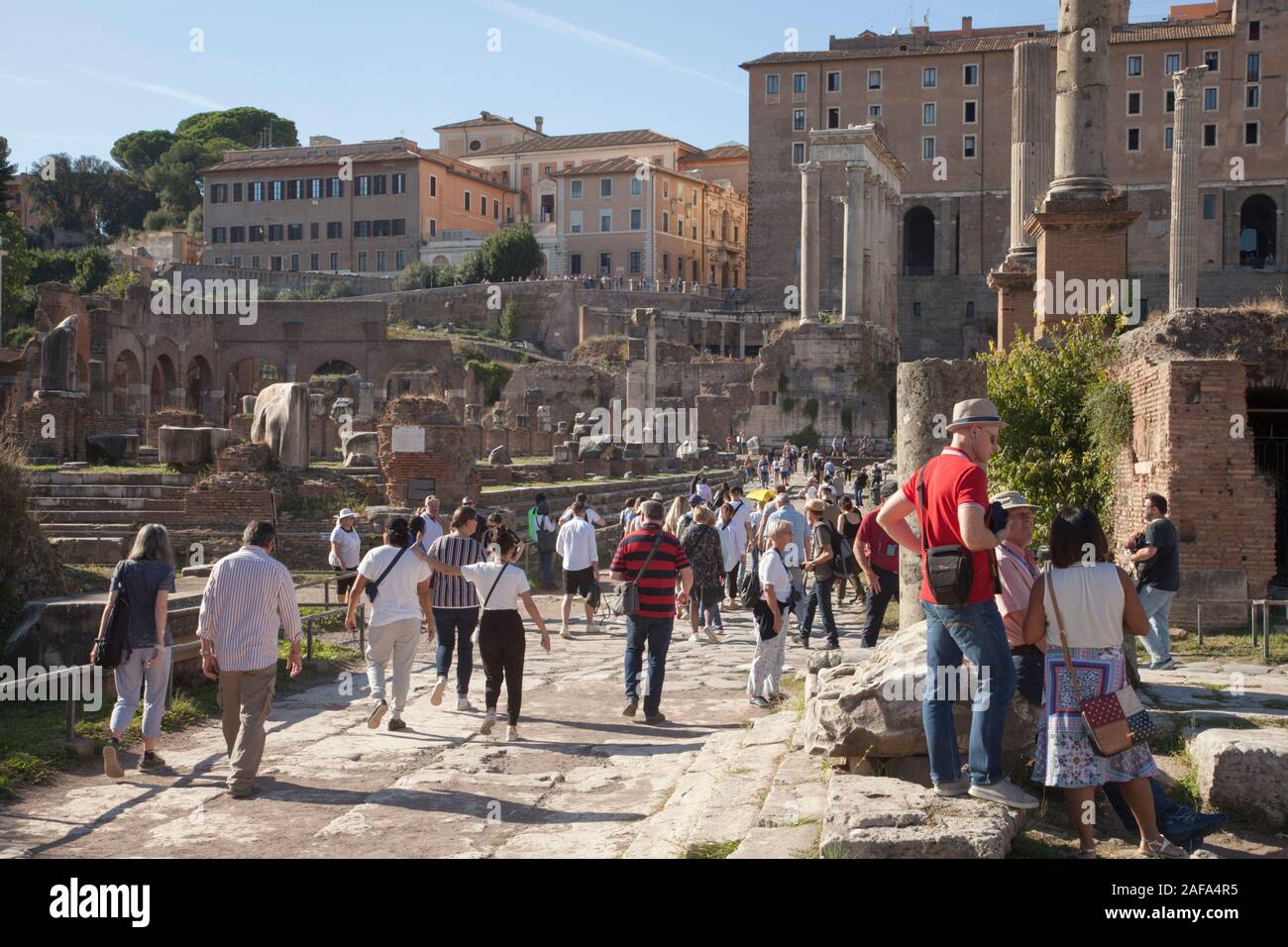 Crowds of tourists at the Roman Forum is a forum (plaza) surrounded by the ruins of several government buildings Stock Photo