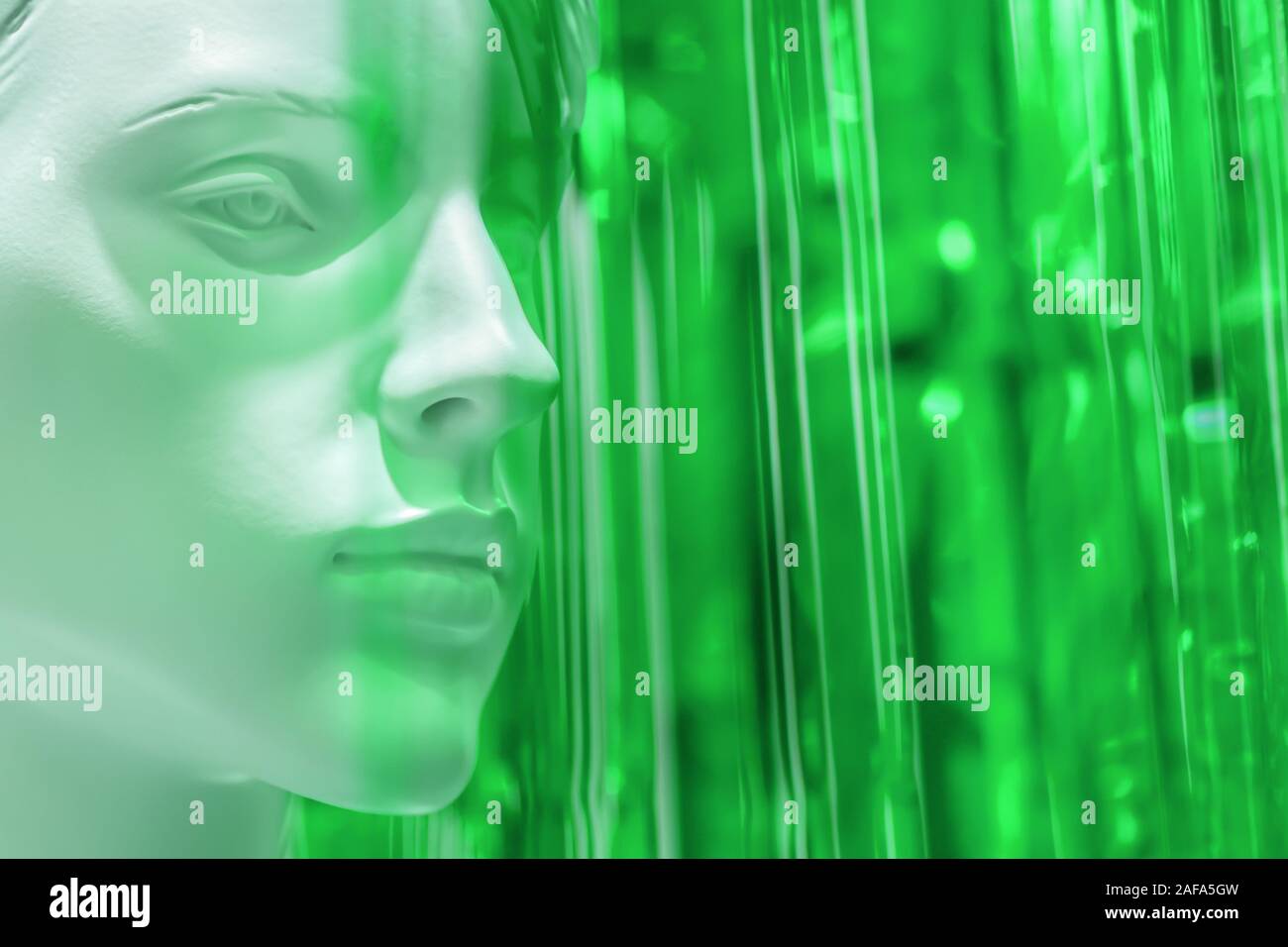 stylish mannequin female woman head close up on warm on bright green blurred background. art concept for advertising and layouts. Copyspace. Stock Photo