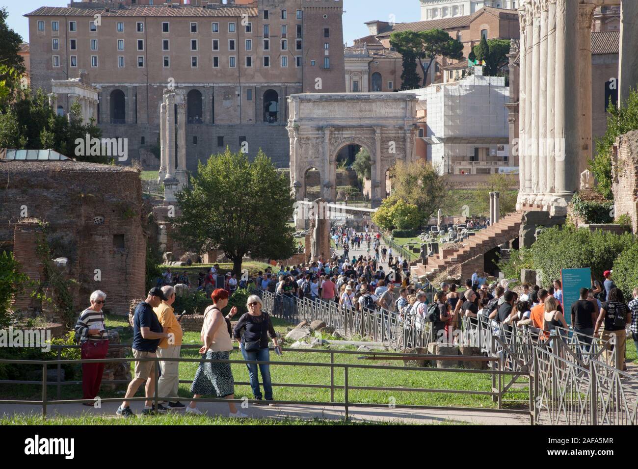 Crowds of tourists at the Roman Forum is a forum (plaza) surrounded by the ruins of several government buildings Stock Photo