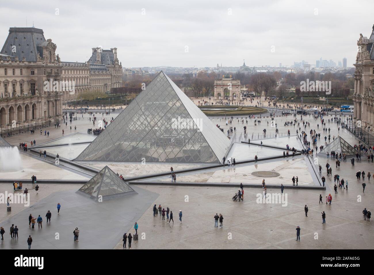 The glass pyramid entrance in the courtyard of the Louvre Museum in Paris looking towards the Arc de Triomphe du Carrousel Stock Photo