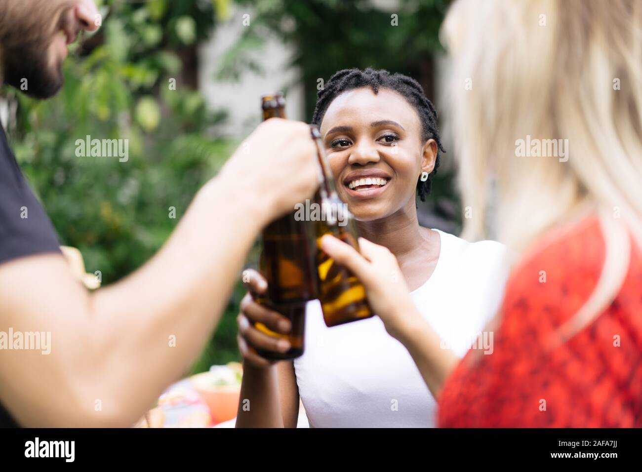 Group of friends toasting beers outdoors. Party people drinks toast celebration. Stock Photo