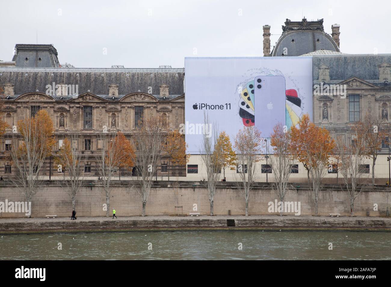 A huge advert for Apple's iPhone 11 on the Louvre art gallery on the banks of the River Seine in Paris Stock Photo