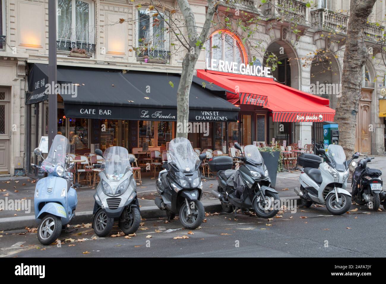 Scooters and motorbikes parked outside Le Fenelon and Le Rive Gauche, traditional cafe bars in Place Saint Michel in Paris Stock Photo