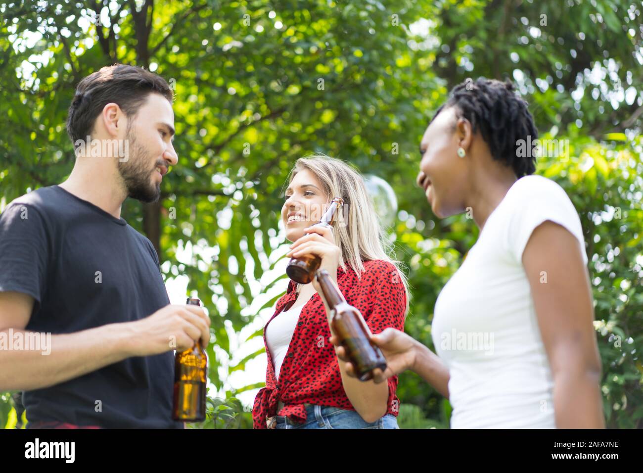 Group of friends toasting beers outdoors. Party people drinks toast celebration. Stock Photo