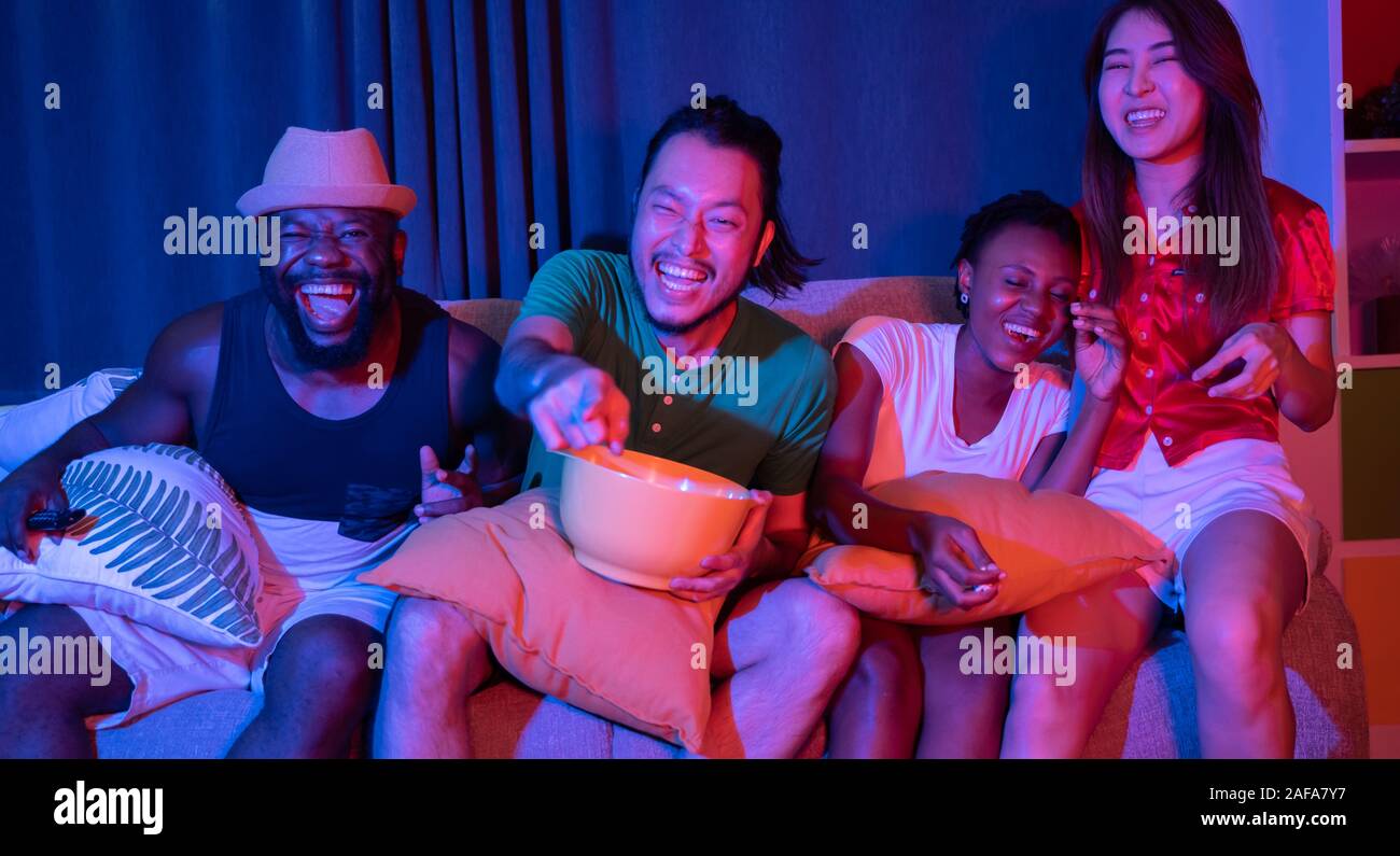 Group of friends having fun at home watching soccer and movies on tv. enjoying and celebrate together Stock Photo