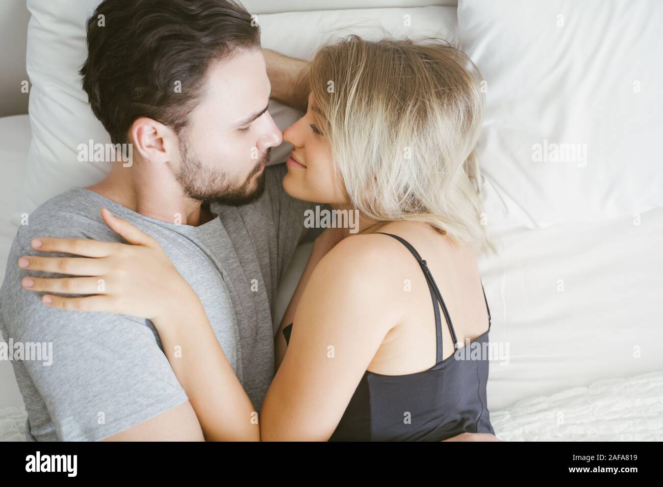 Young couple in the bed wake up in the morning. loving couple in bedroom Stock Photo