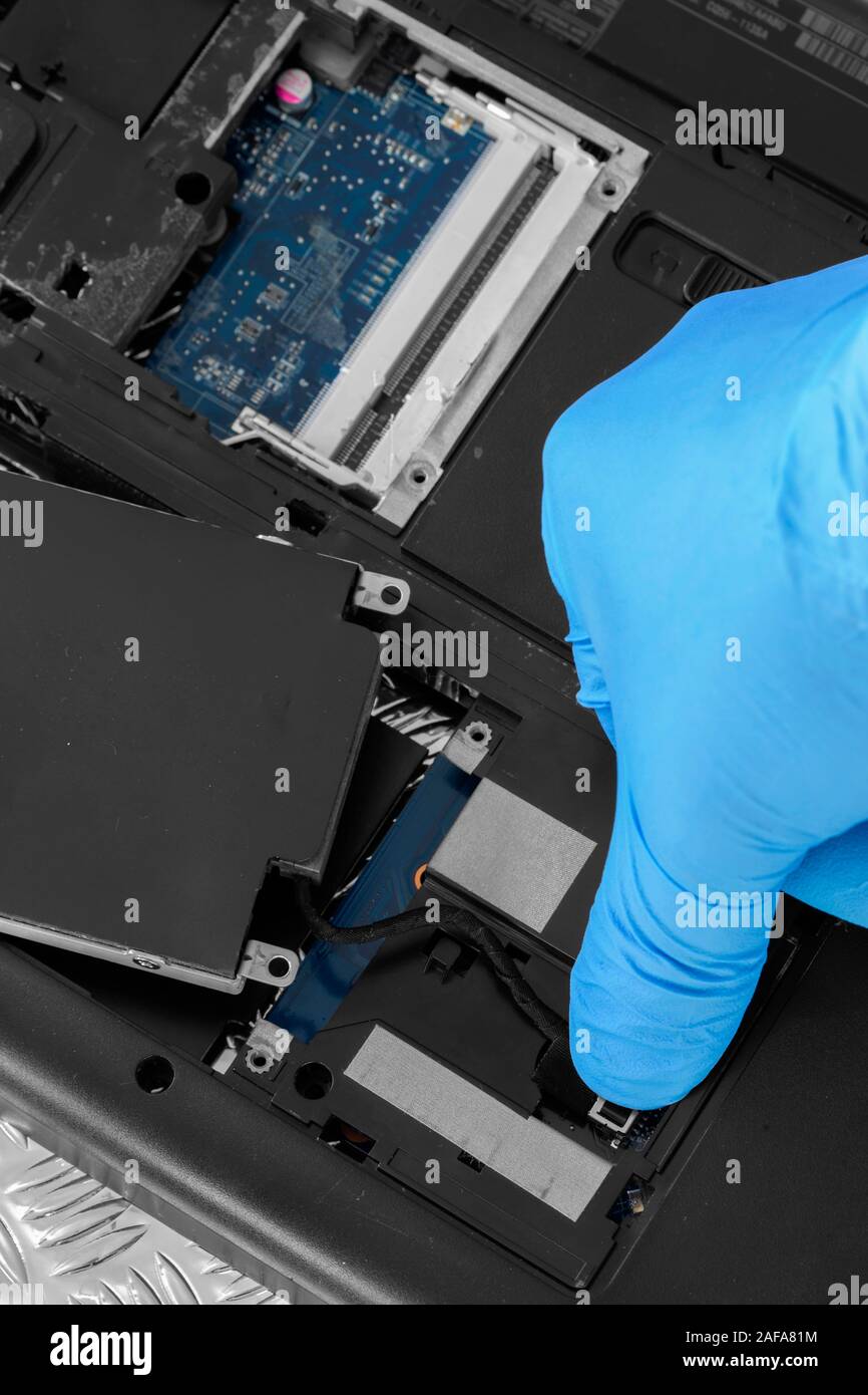 Technician connecting hard drive HDD cable to a laptop computer.  Computer updrade concept Stock Photo