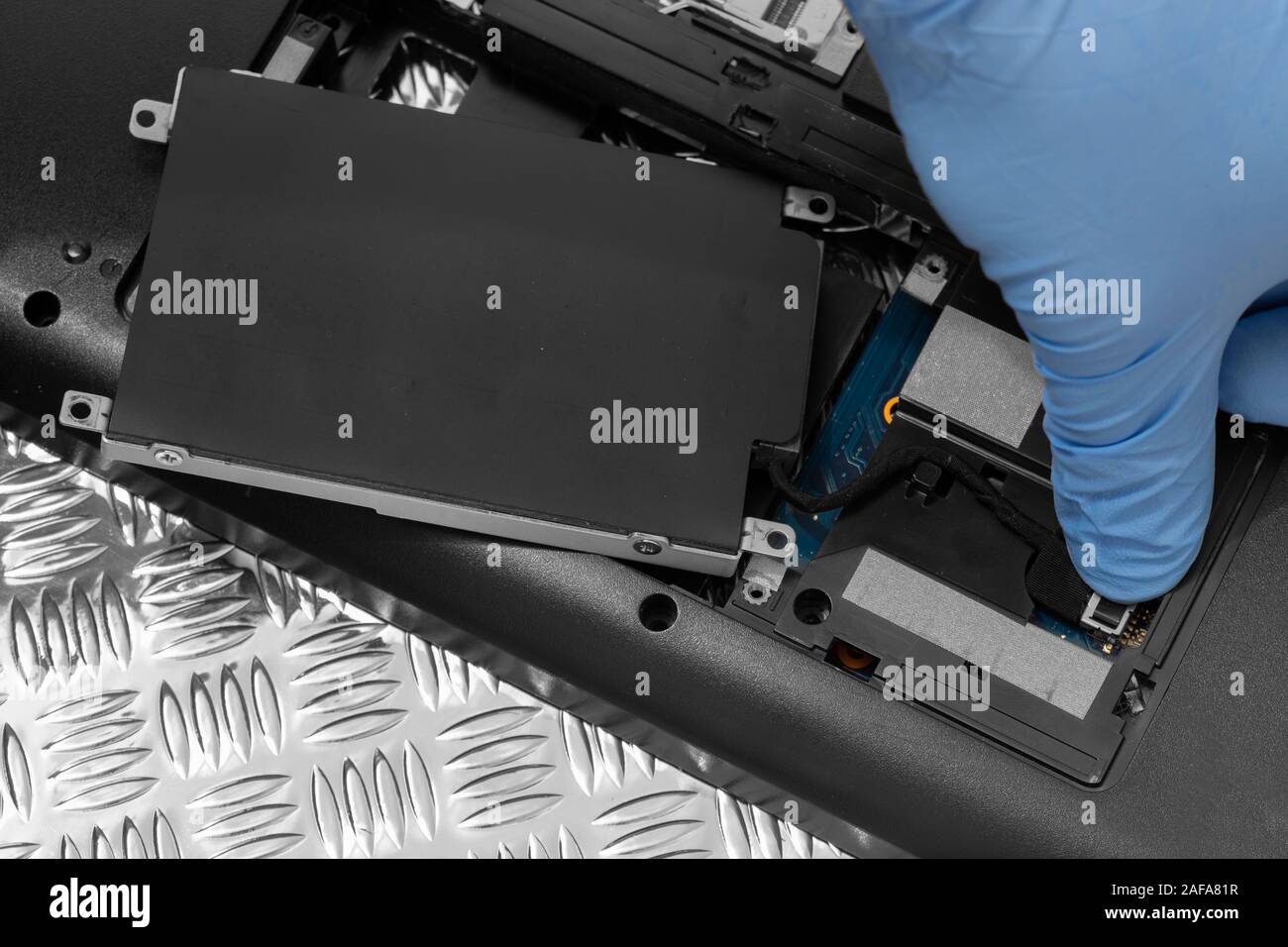 Technician connecting hard drive HDD cable to a laptop computer.  Computer updrade concept Stock Photo