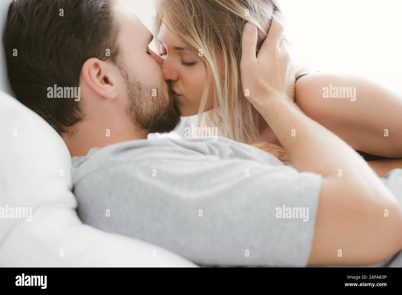 Young couple kissing in the bed .loving couple in bedroom Stock Photo