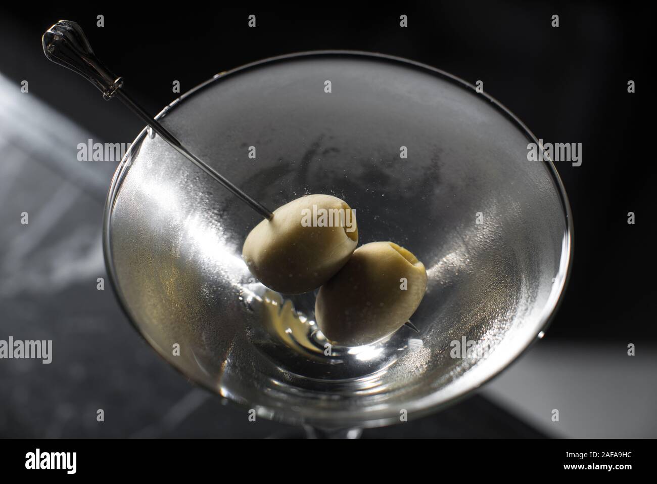 Dry Martini cocktail on a bar desk. black background. view on top Stock Photo