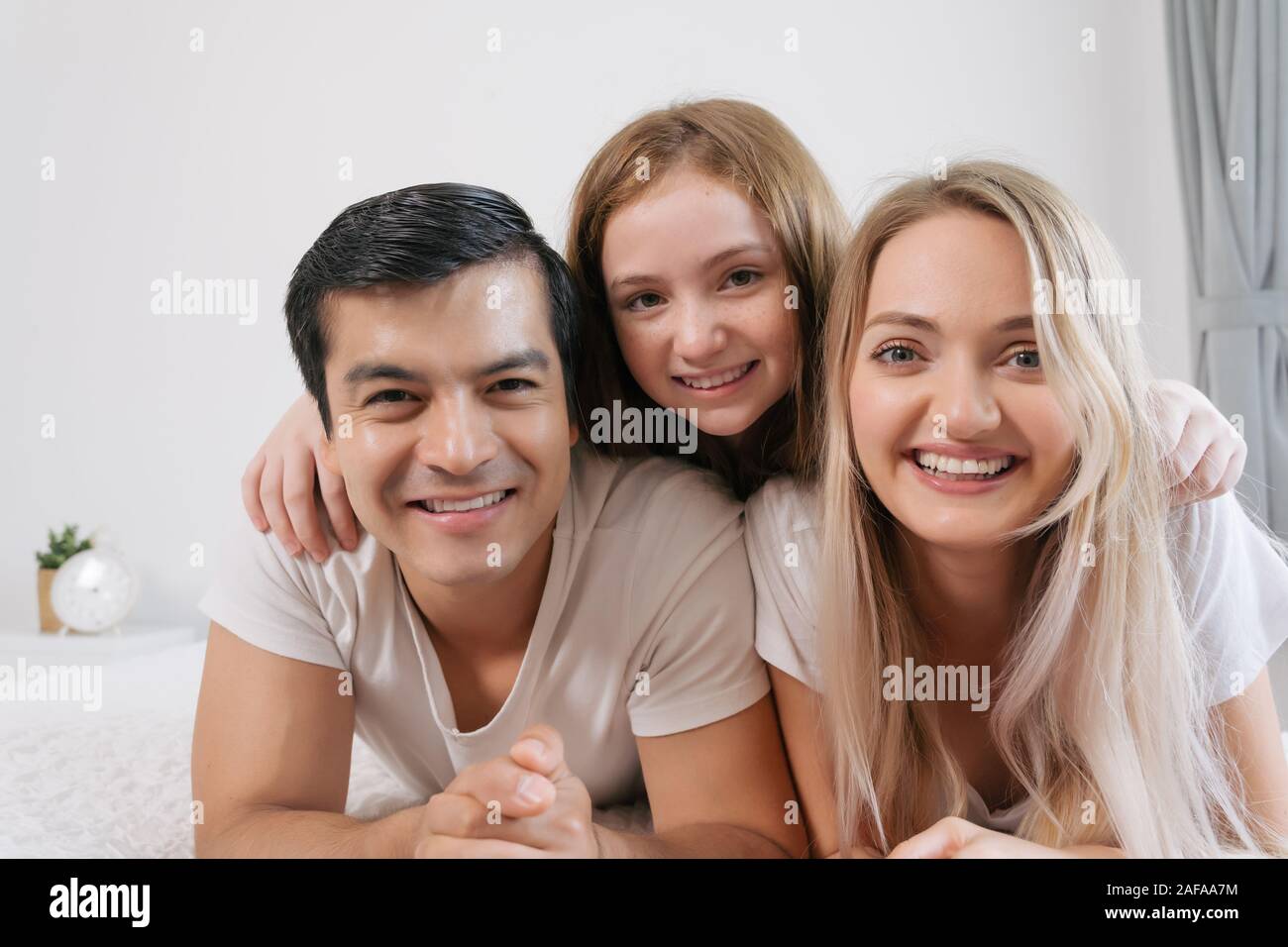 Portrait happy family spending time together on bed in bedroom. family and home concept Stock Photo