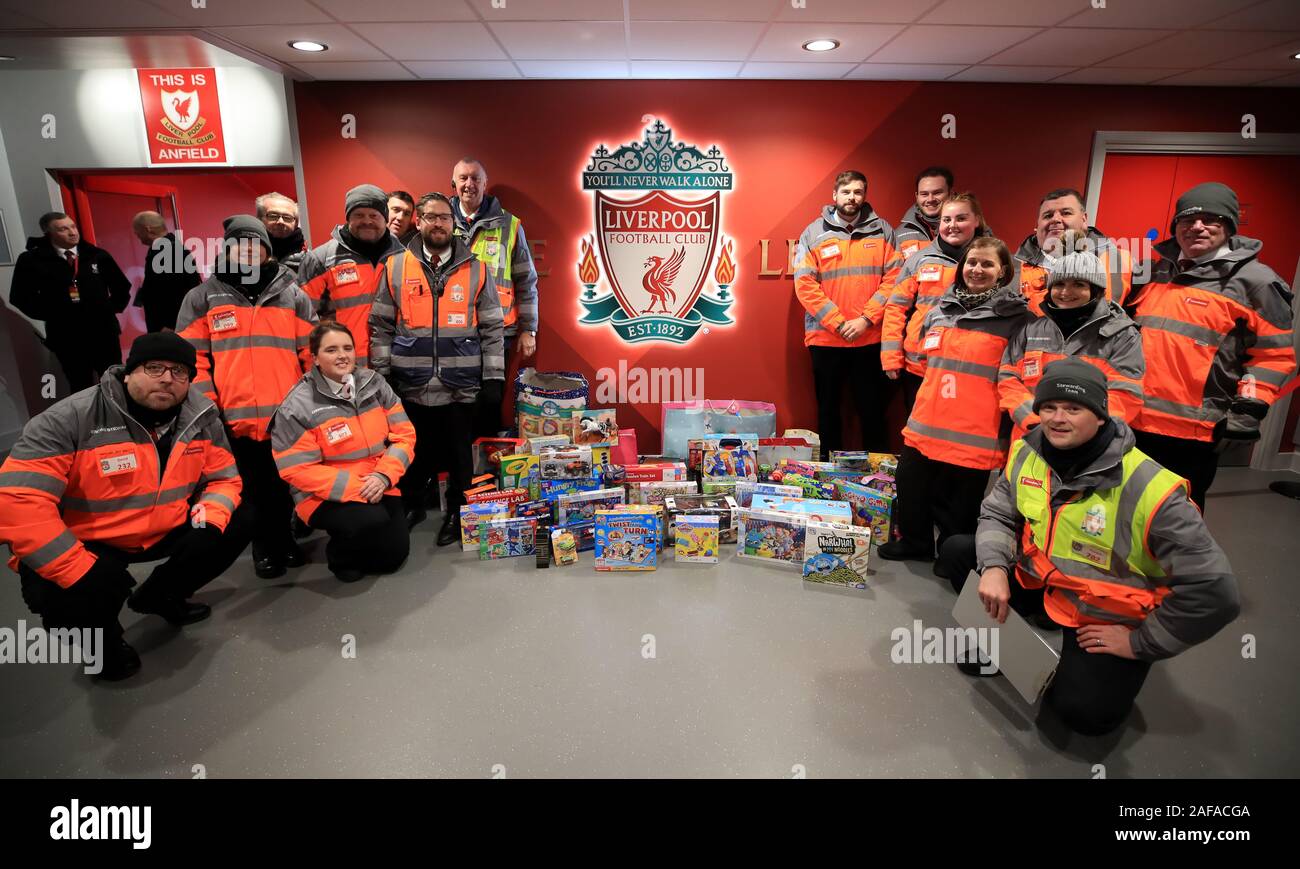 Staff at Liverpool FC alongside toys that they ve donated to the
