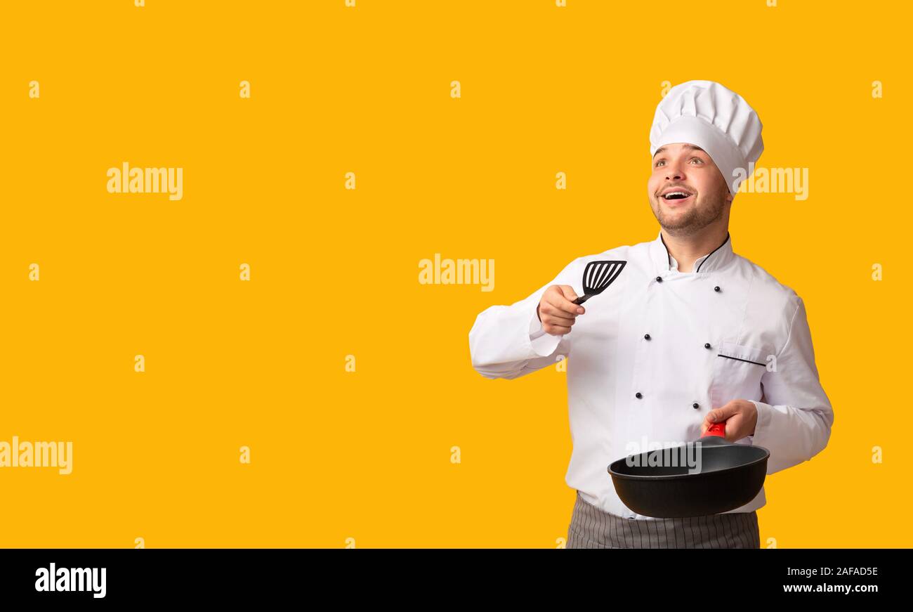 Chef Guy Holding Pan Throwing Invisible Food Standing, Studio Shot Stock Photo